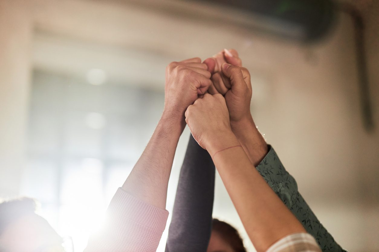 workers hands raised together