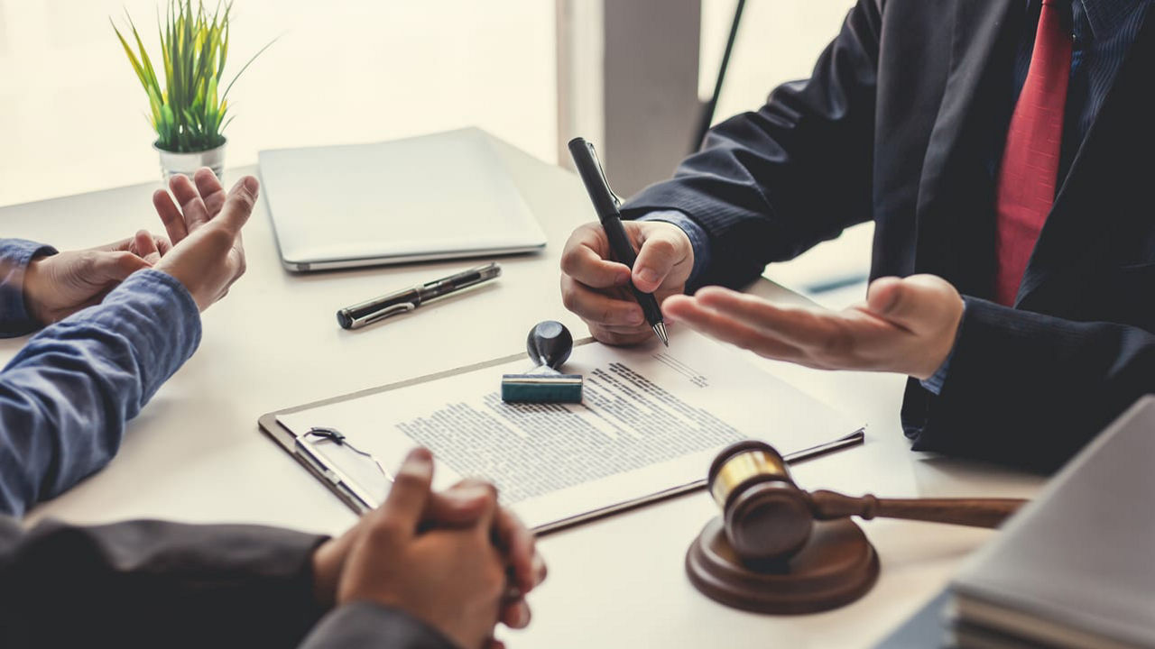 A group of business people sitting at a table with a gavel.