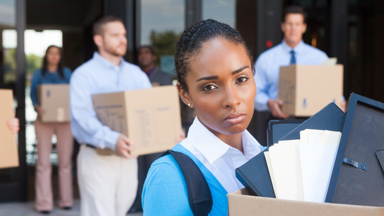 A group of people carrying boxes in front of a building.