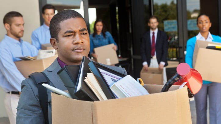A group of business people carrying boxes.