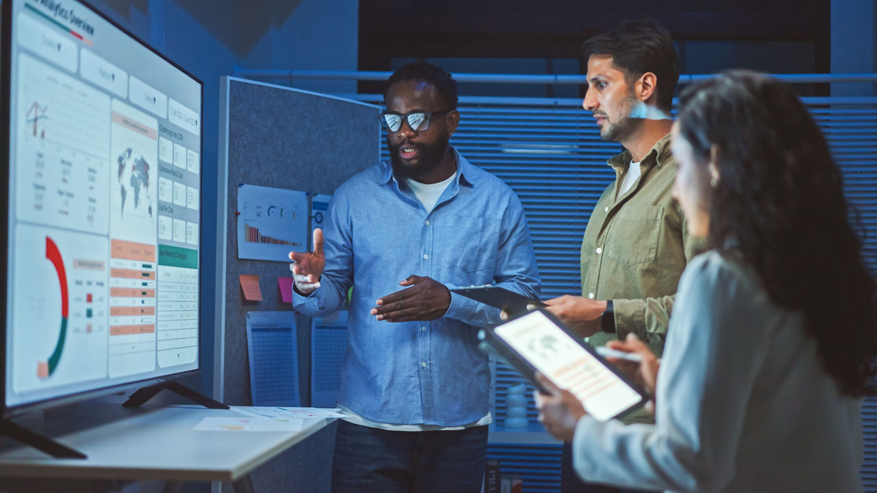 A team of multiethnic developers is meeting to review the data analysis of marketing from social media platforms.