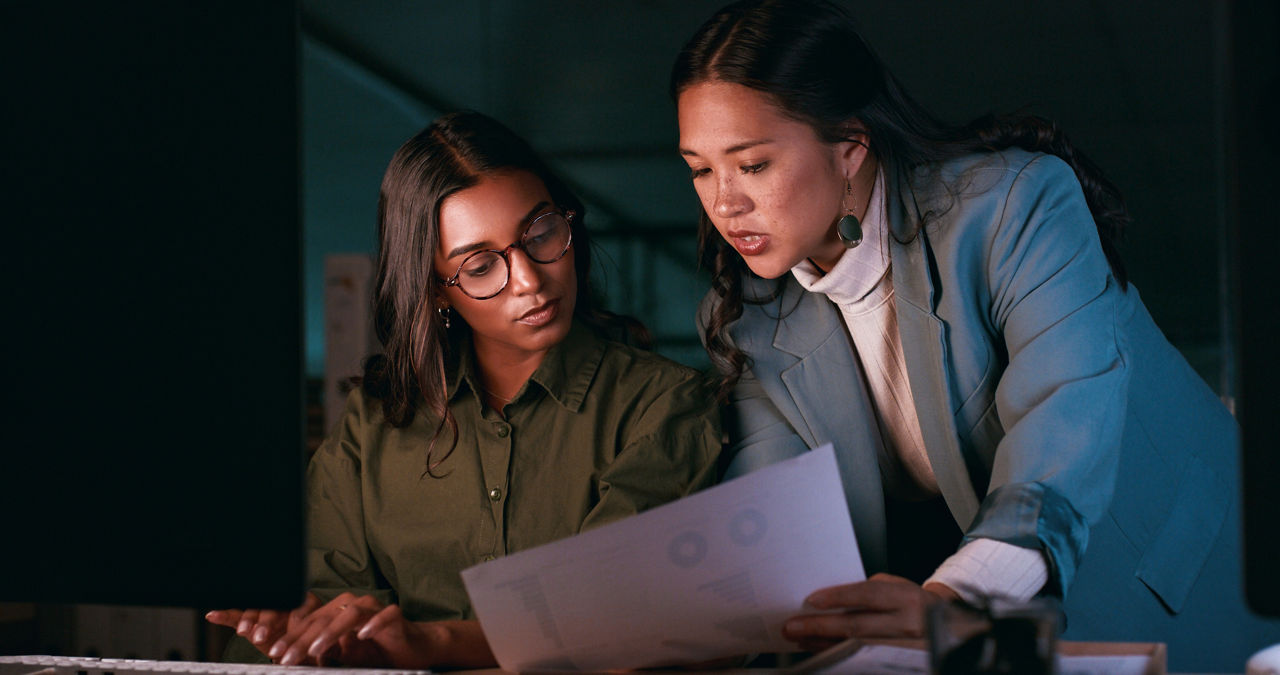 Two business leaders looking at report and discussing