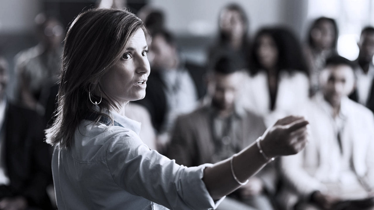 A woman is giving a presentation to a group of people.