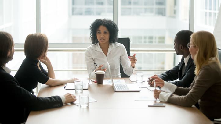 A group of business people sitting around a conference table.