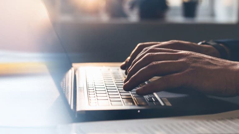 A person typing on a laptop computer.