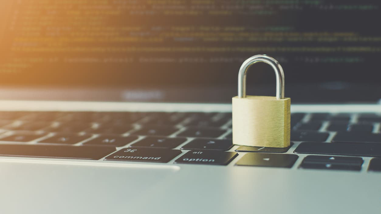 A padlock sits on top of a laptop keyboard.