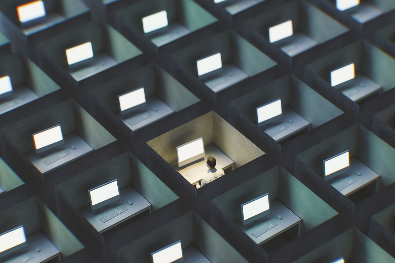 Surreal image of office cubicles with man working late. 3D generated image.