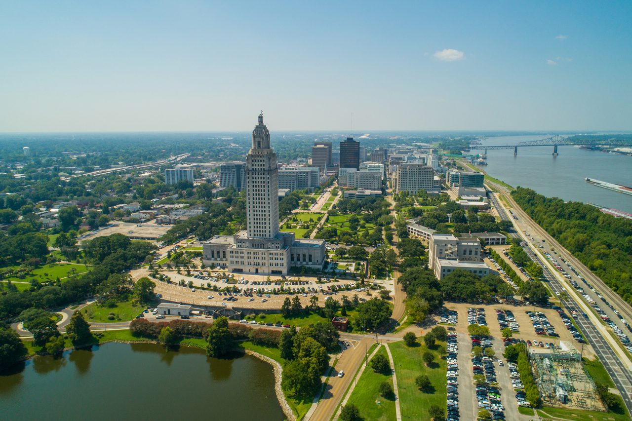 State Capitol of Louisiana in Baton Rouge with downtown in the background as well as the Mississippi River and in the far distance a bridge over it.