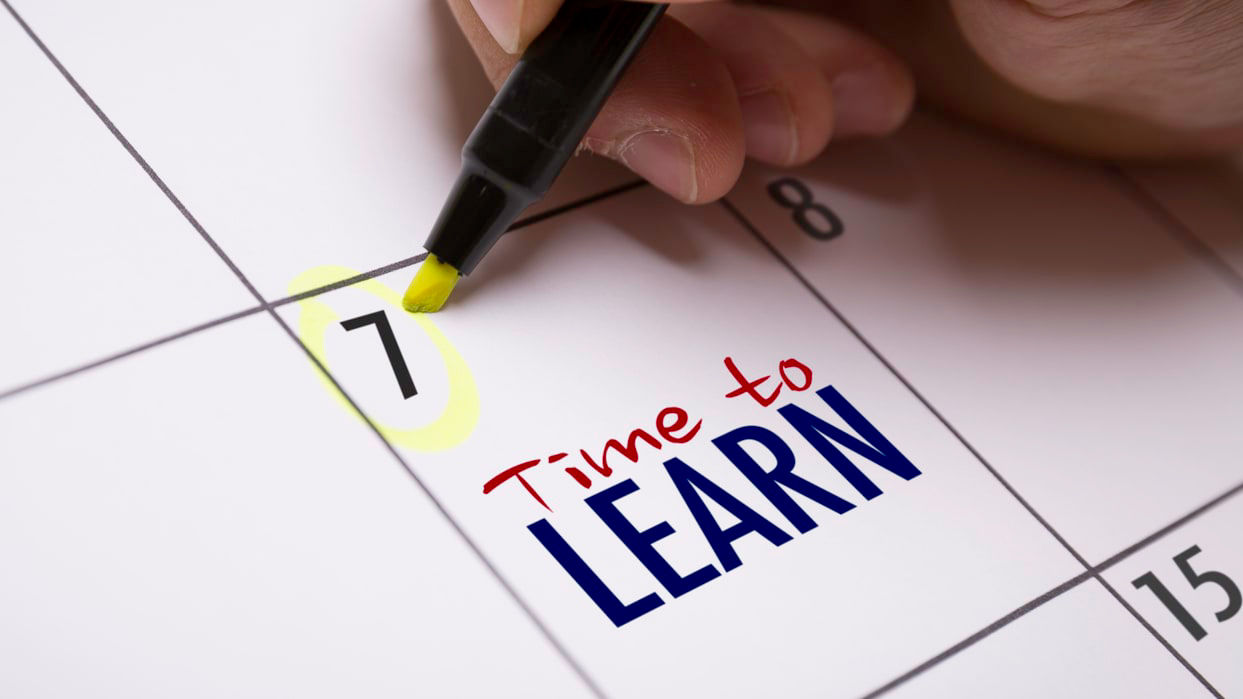 A person writing the word time to learn on a calendar.