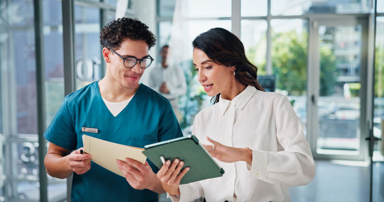 male and female health care workers comparing notes