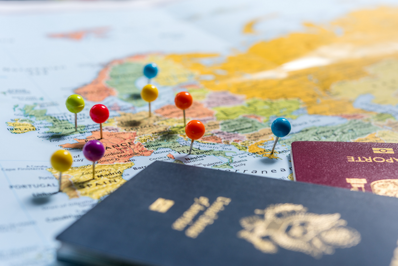Maps with pins and passports, planning the holidays.