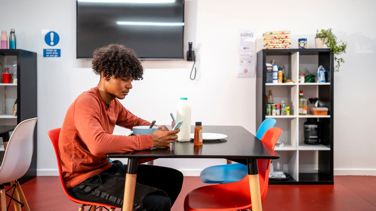 A young man sitting at a table in a room.