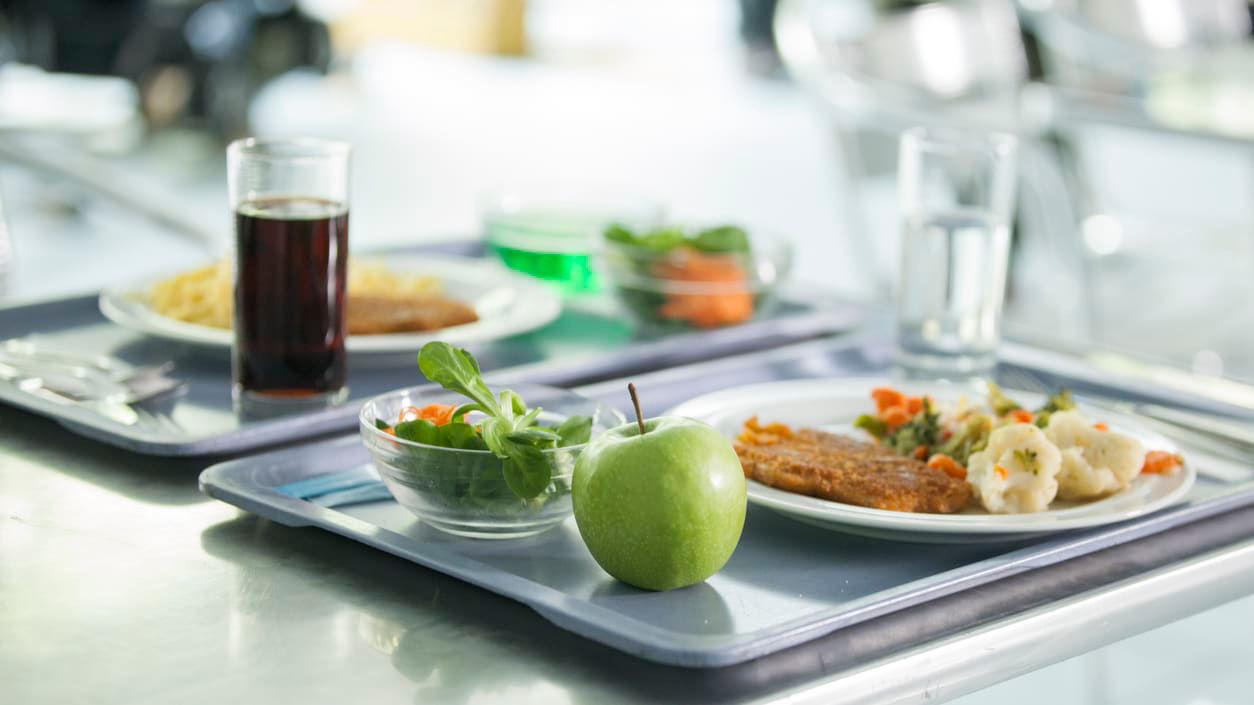 A tray of food on a table in a school cafeteria.