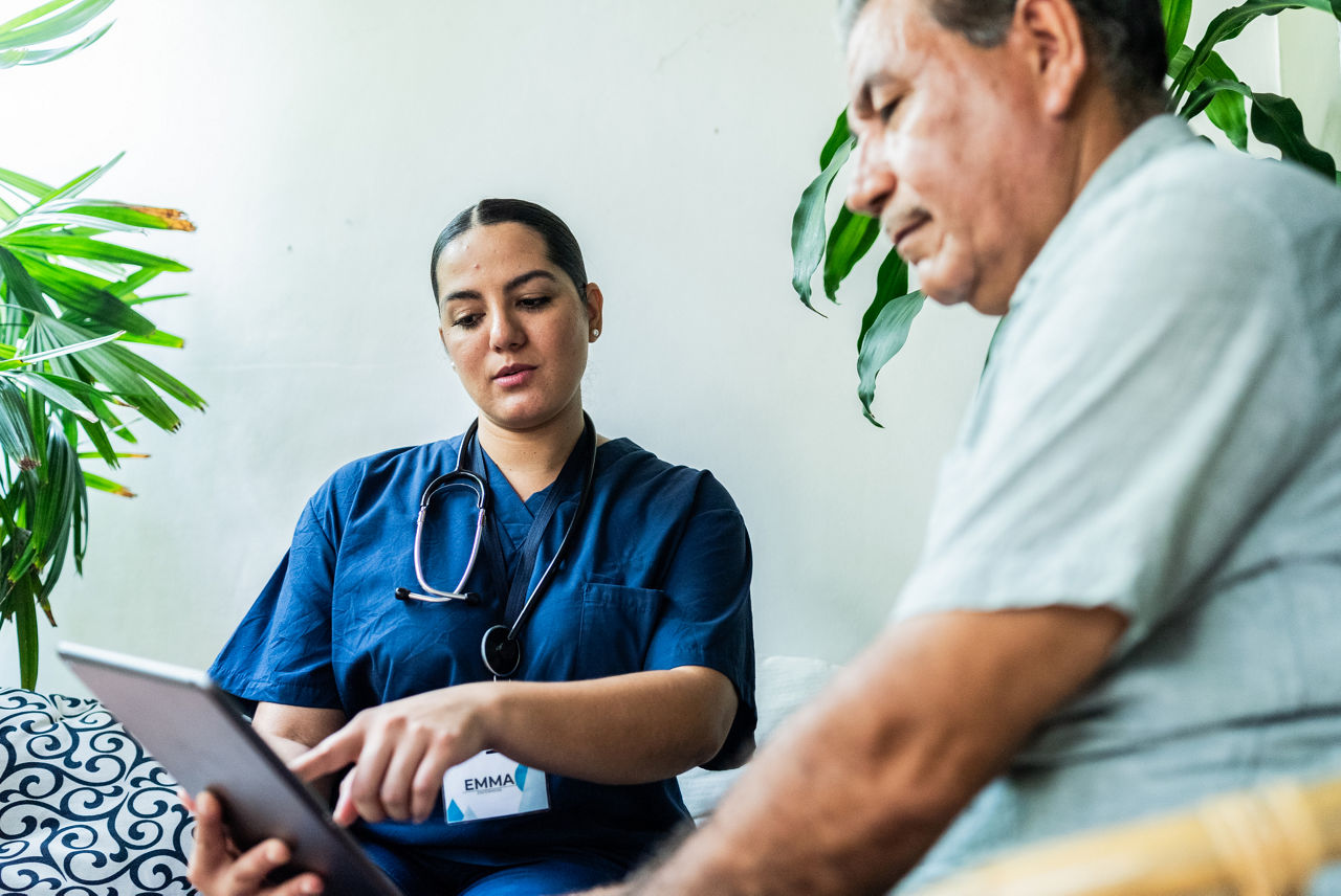 A female nurse discusses a medical form with a male patient.