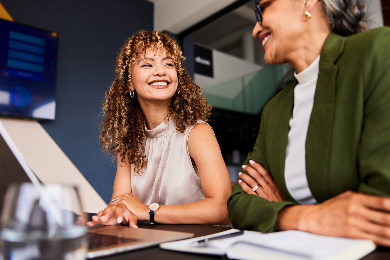 Two coworkers having a discussion during an office meeting.
