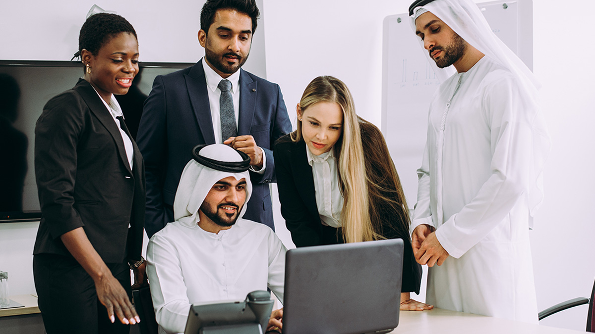 Workers looking at a laptop together
