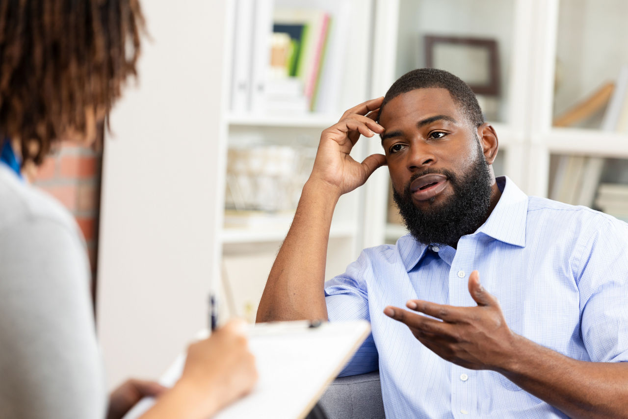 A man in a blue shirt actively engages in conversation, expressing his thoughts and concerns while receiving guidance.