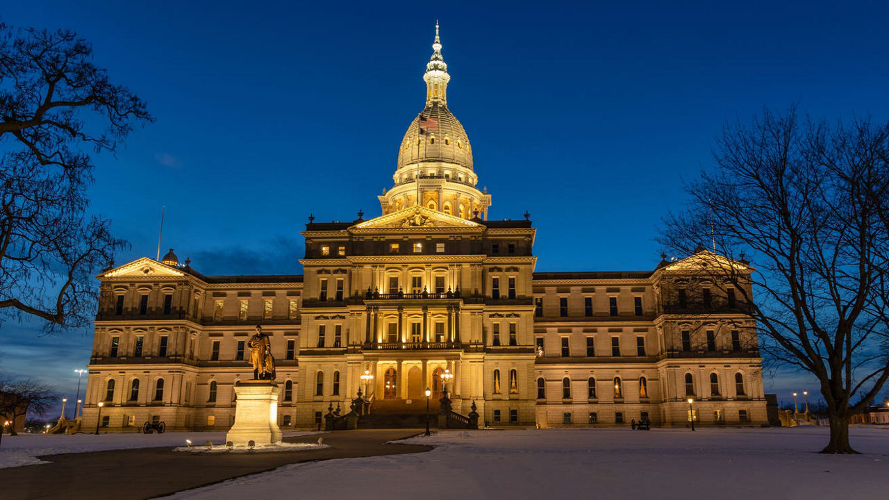 The state capitol building is lit up at night.