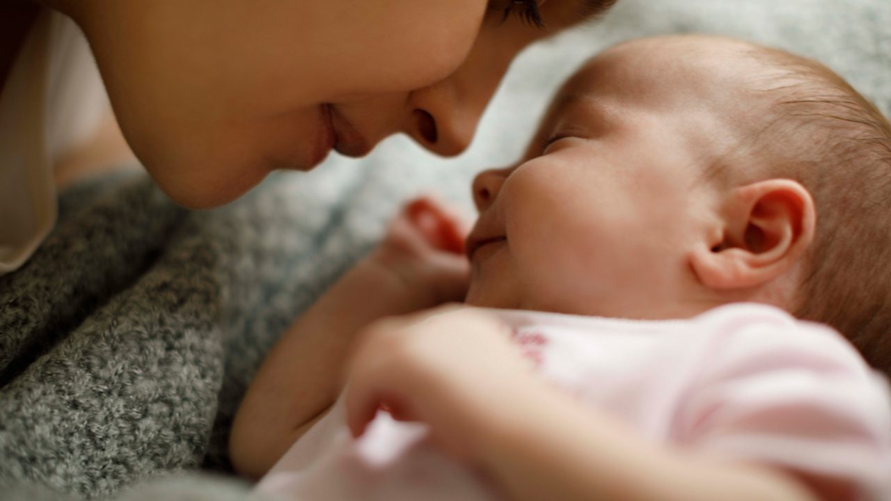 A woman is holding a baby in her arms.