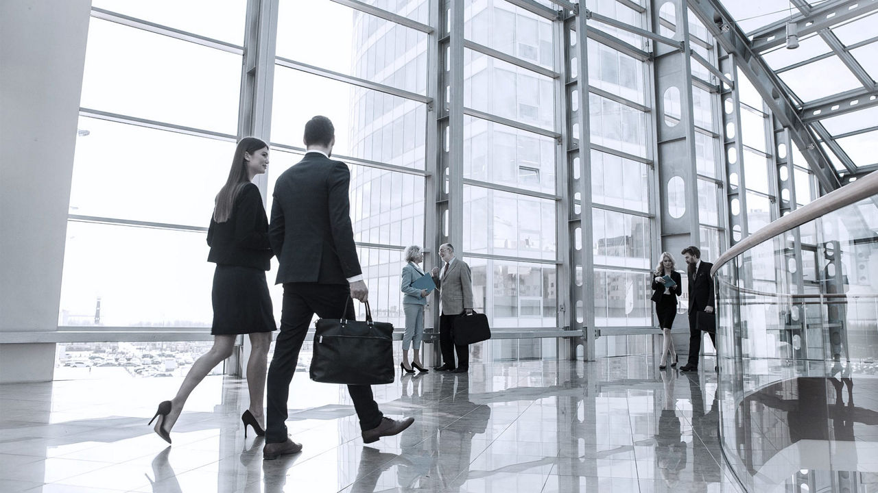 A group of business people walking in an office building.