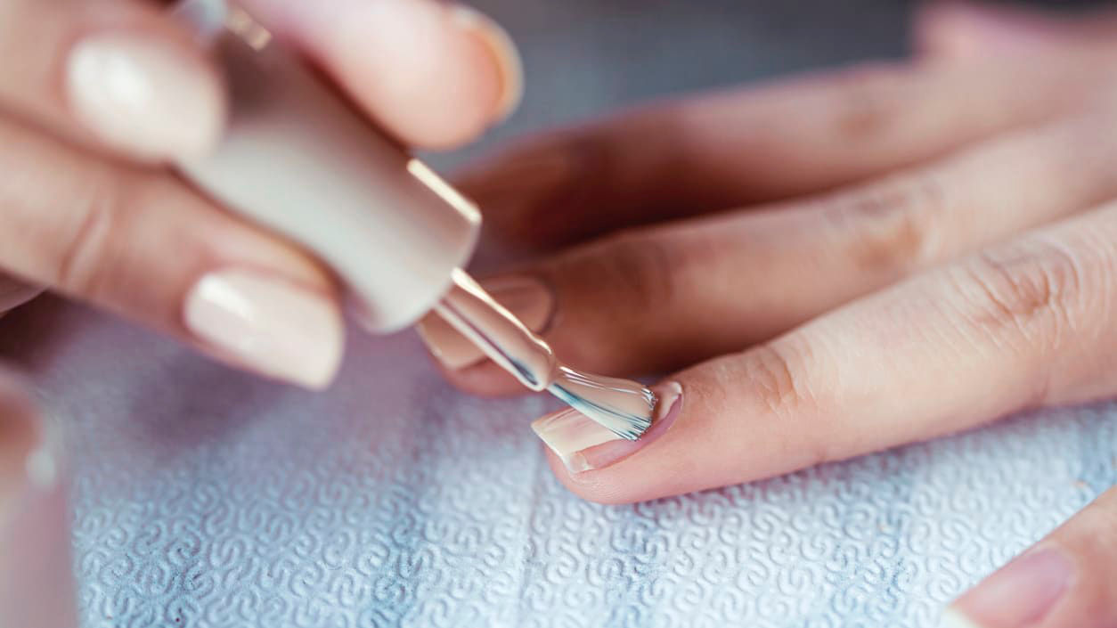 A woman is getting her nails done by a manicurist.