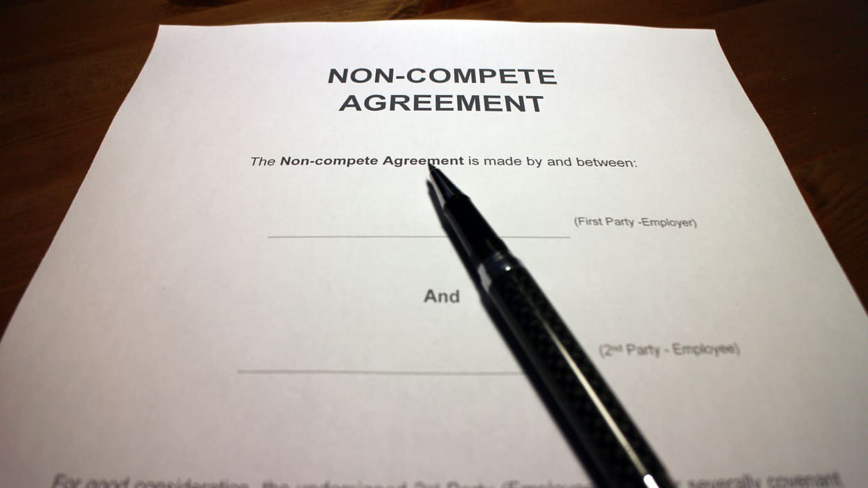 A pen sits on top of a non-compete agreement.