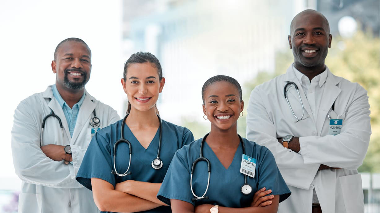 A group of doctors standing together with their arms crossed.