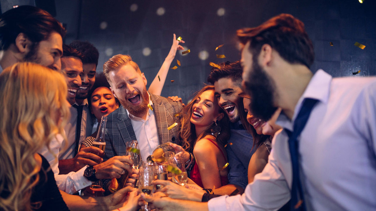 A group of friends celebrating at a party with confetti.