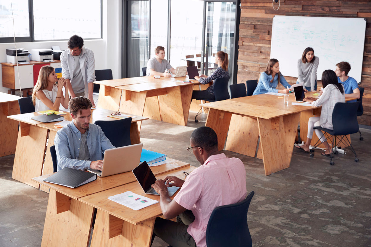 Young adult colleagues working in busy office, elevated view