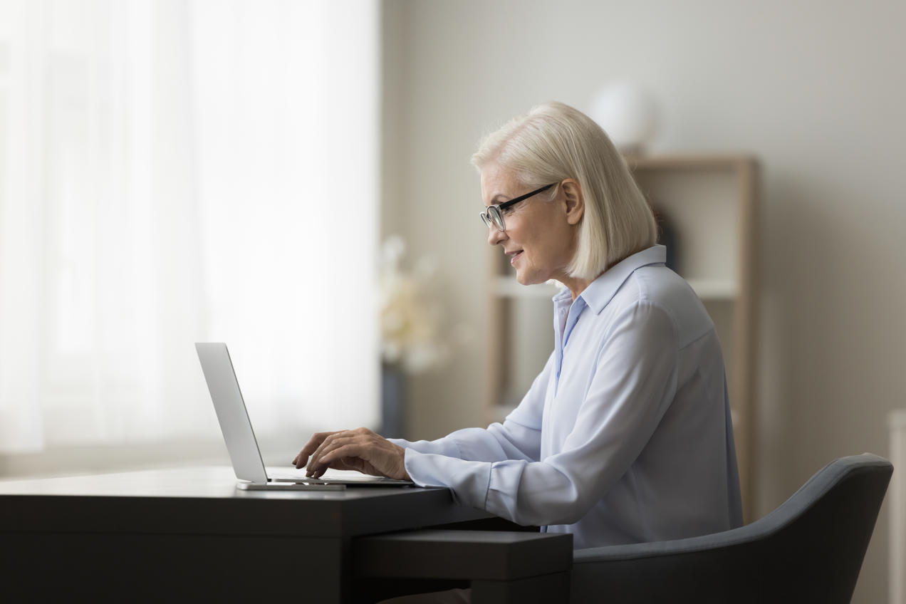 Older office worker using laptop.
