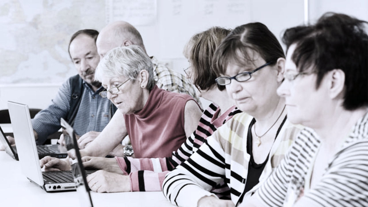 Older workers sitting in front of laptops