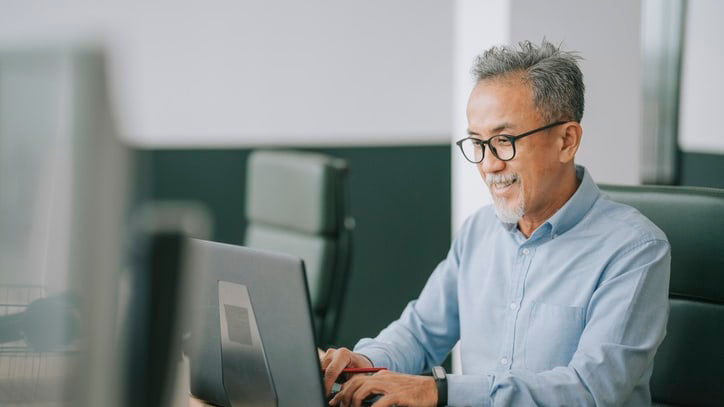 A man working on a laptop in an office.