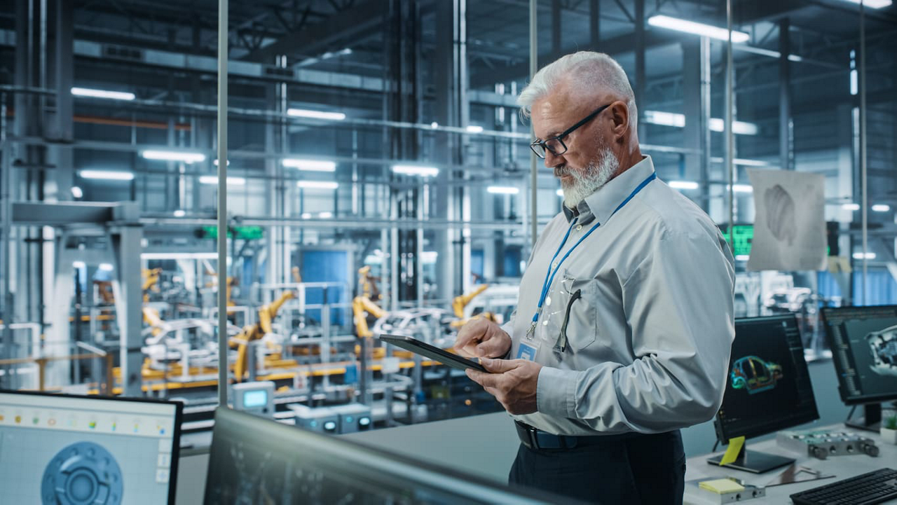 Older man working on factory floor.