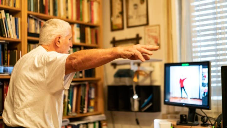 An older man is playing a video game on his computer.