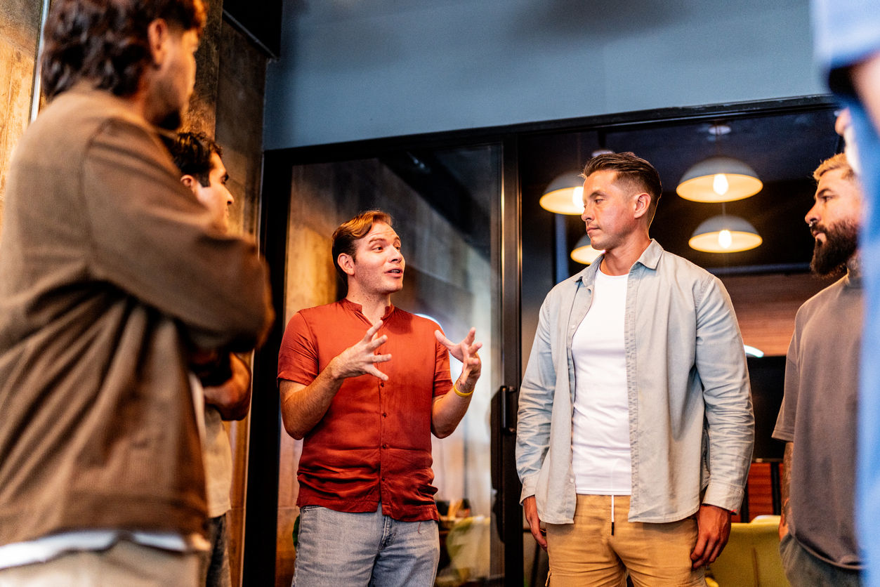 Male friends talking indoors