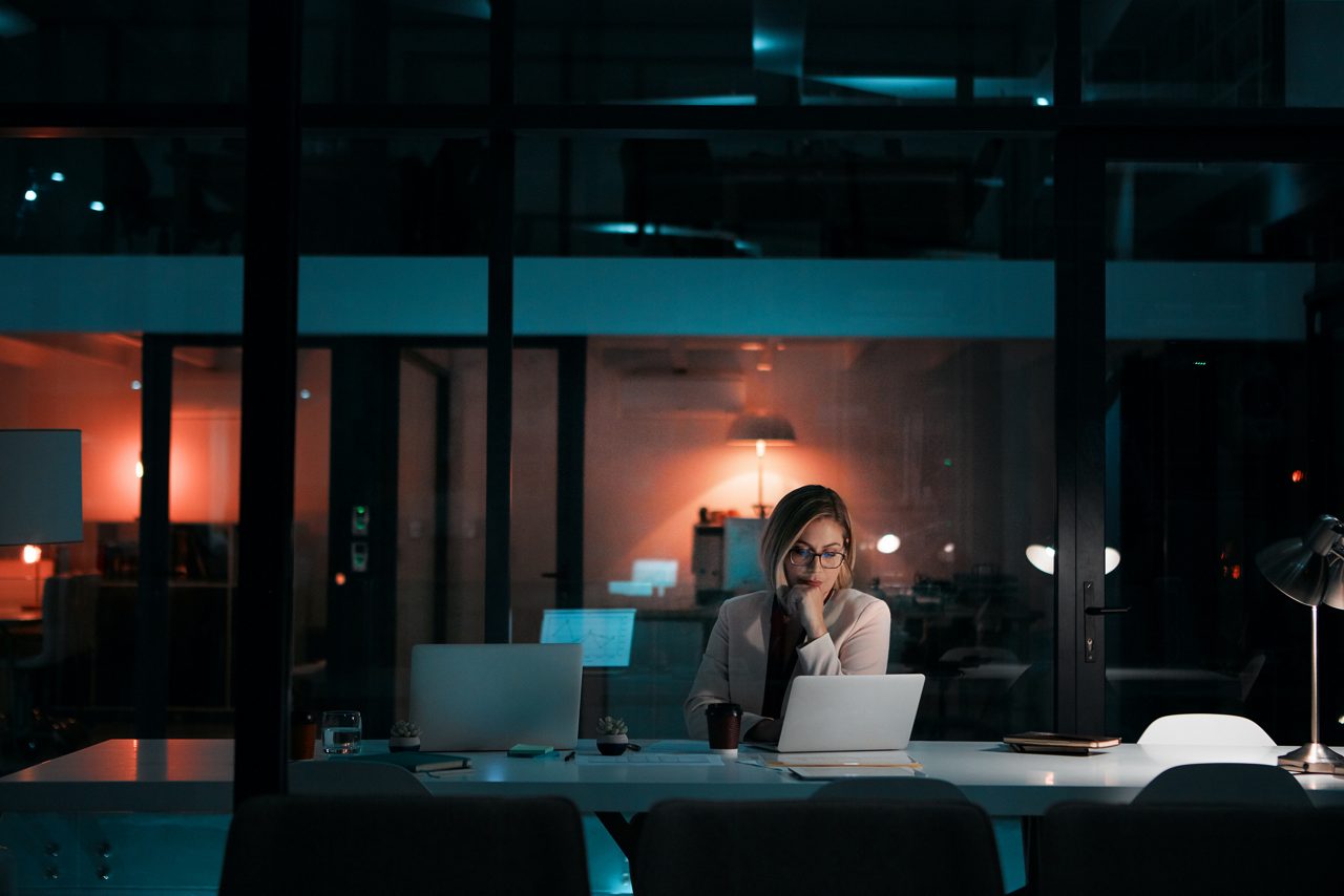 A worker at her laptop at night.