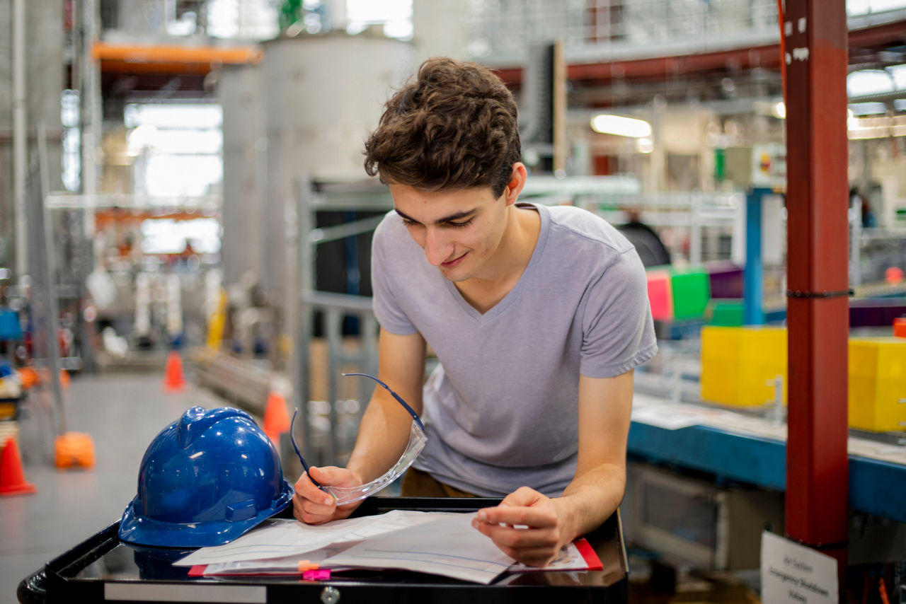 A front view of a young man learning skills and entering information on the sheets provided