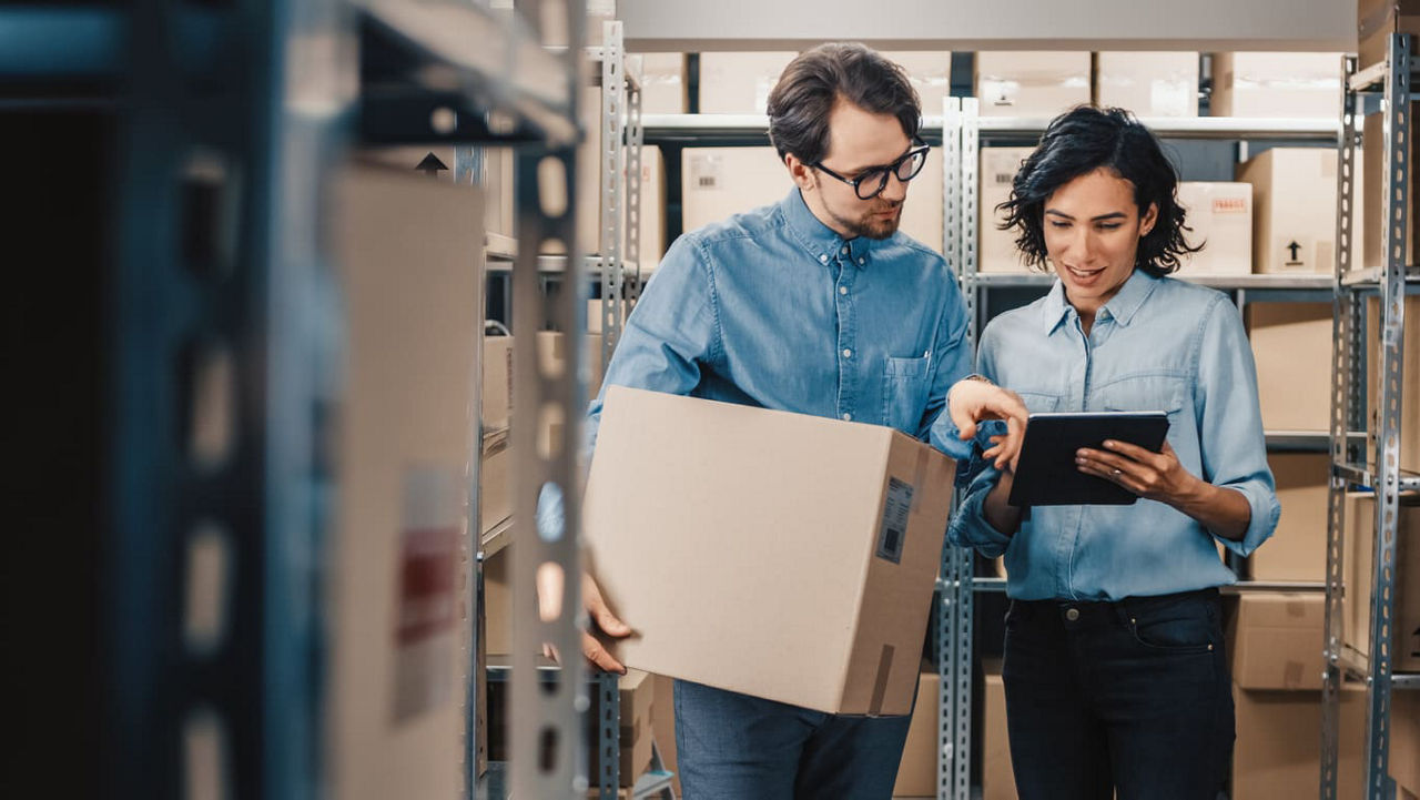 Two people looking at a tablet in a warehouse.