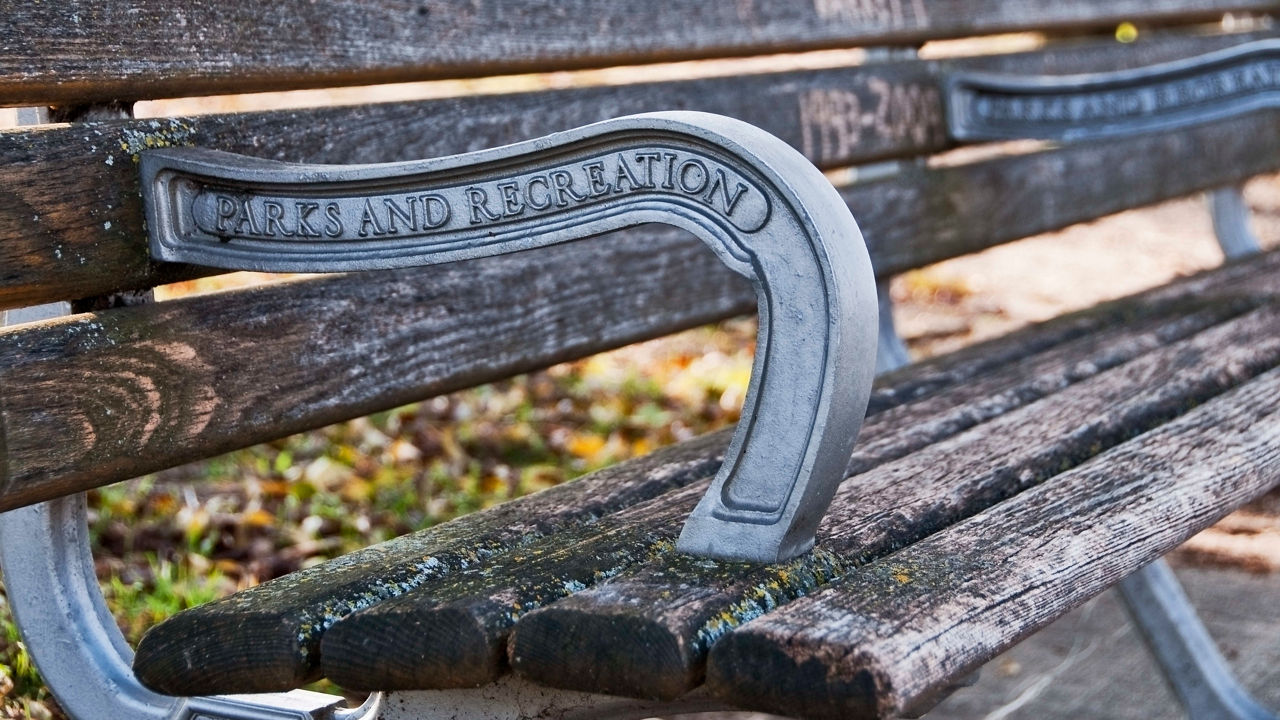 A wooden bench with a metal handle.