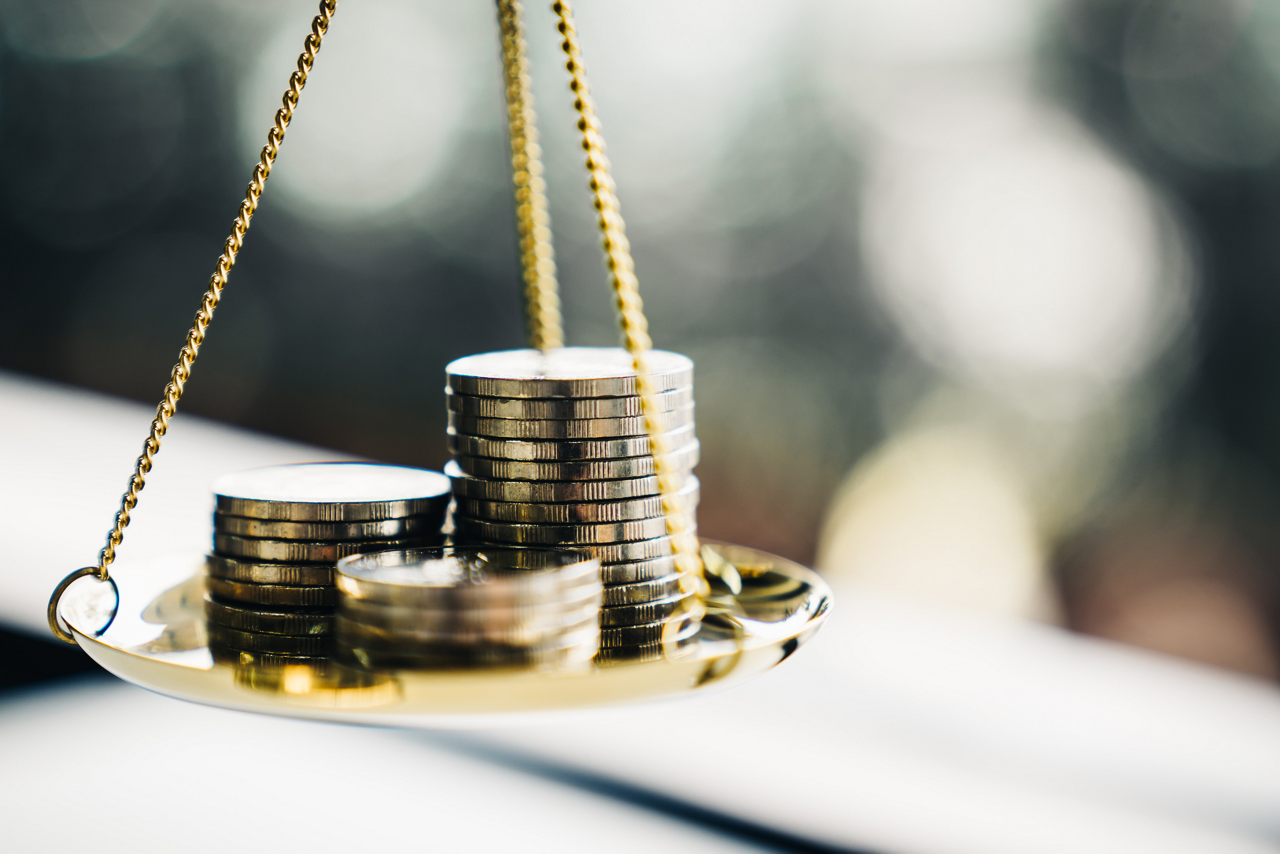 Coins stacked on a balance scale. 