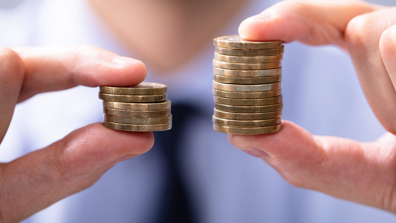 A man is holding two stacks of coins in his hands.