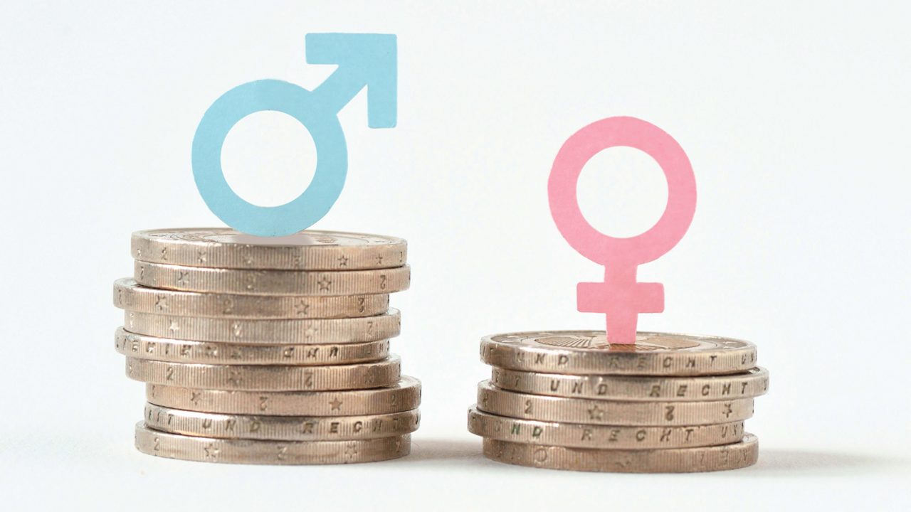 Female and male symbols on a stack of coins.