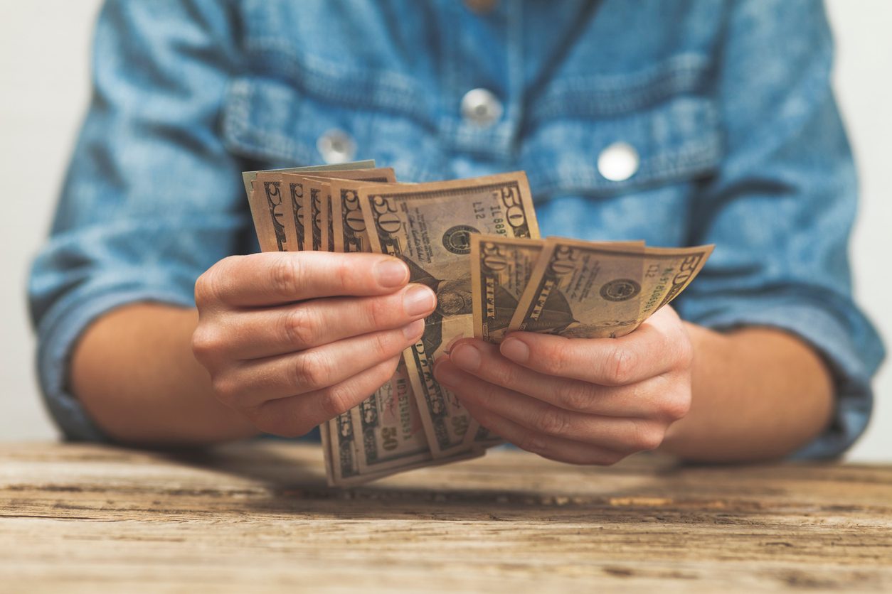 Man holding cash in hand, indicating a pay raise