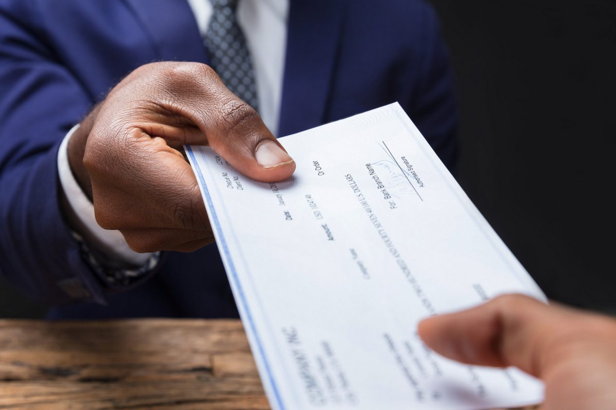 person receiving a paycheck from a boss