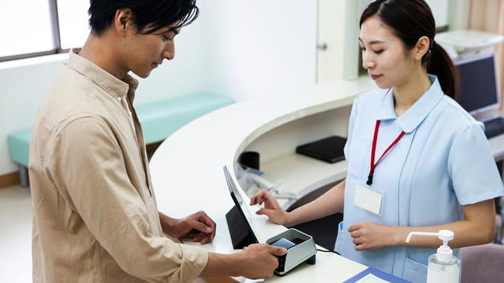 A man and a woman standing at the reception desk.