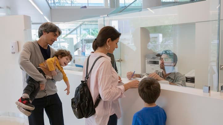 A group of people standing at a counter at a bank.