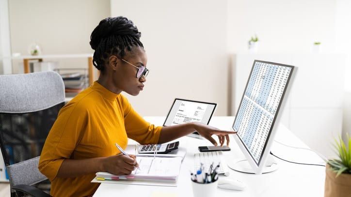 A woman working at a desk with a computer.