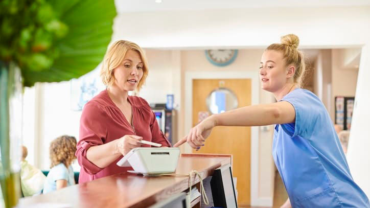 A nurse at the front desk of a hospital.