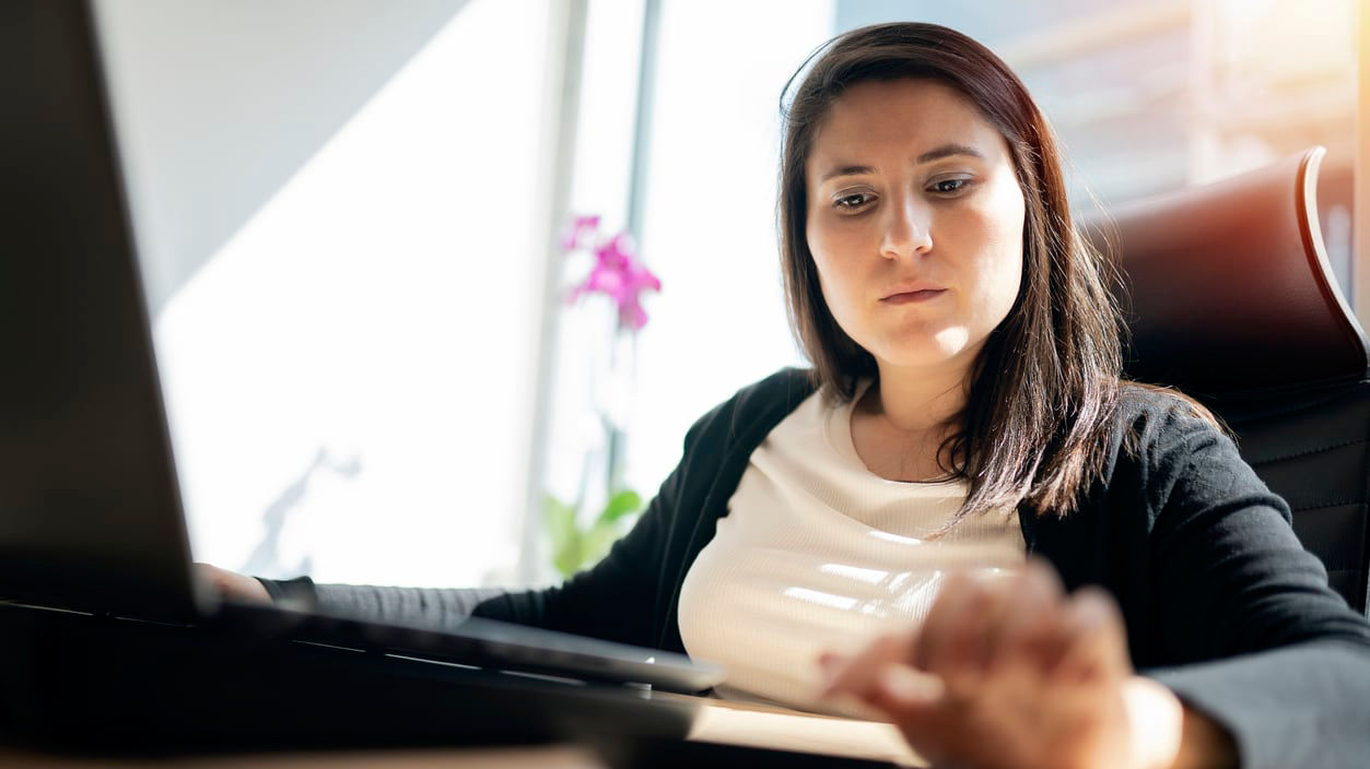 A woman sitting at a desk with a laptop.