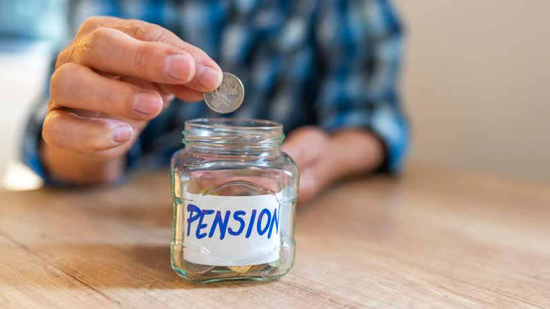 A man putting a coin into a jar with the word pension on it.